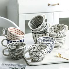 five coffee cups sitting on top of a white tray next to a spoon and fork