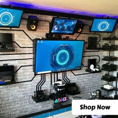 a wall with multiple monitors on it and some wires hanging from the ceiling above them