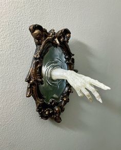 a white glove hanging from the side of a wall mounted light fixture in a room