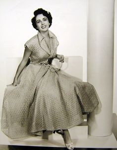 an old photo of a woman sitting on a chair