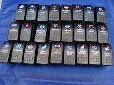 a bunch of remotes sitting on top of a blue cloth covered table next to each other