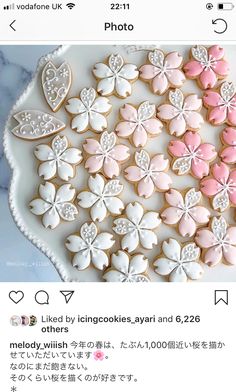 cookies decorated with pink and white icing are on a plate next to an instagram page