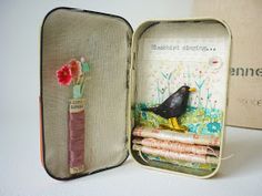 an open suitcase with a bird and flowers on it's handle, sitting next to a book