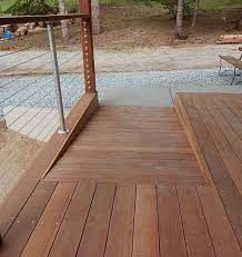 a wooden deck with chairs and table on it