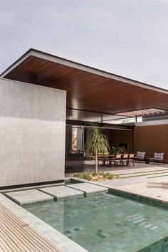 an outdoor swimming pool in the middle of a house with wooden flooring and walls