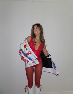 a woman dressed in red and white is holding a giant candy bag while posing for the camera