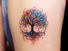 a colorful tree tattoo on the back of a woman's thigh, with circles and dots around it