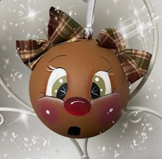 a brown ornament with a bow on it's head and eyes is hanging from a wire