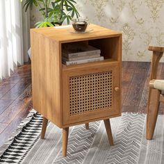 a small wooden cabinet sitting on top of a hard wood floor next to a chair