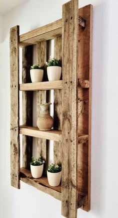 an old wooden shelf with pots and vases on the top, hanging from it's side