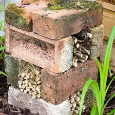 a pile of bricks sitting in the middle of some grass and dirt next to a planter