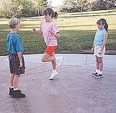 three children are playing with a frisbee in the park