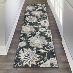 a black and white floral runner rug on a wooden floor in a hallway with hard wood floors