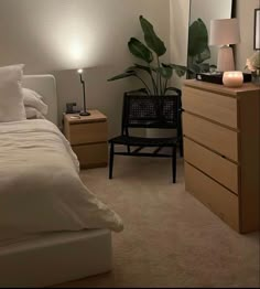 a bedroom with a bed, dresser and lamp on it's side table in front of the mirror