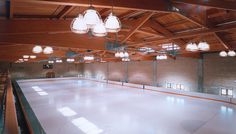 an indoor ice rink with chandeliers hanging from the ceiling