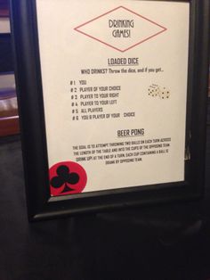 a framed sign with instructions for drinking games and dices on it's side