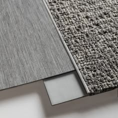 a close up view of an area rug with grey and white carpeting on it