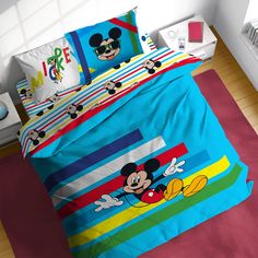 a bed with mickey mouse comforter and matching pillowcases on top of it