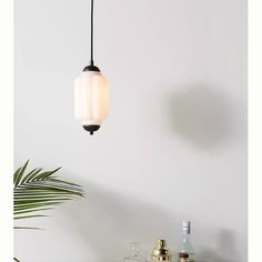 a light hanging from a ceiling next to a table with bottles and glasses on it