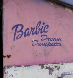 graffiti on the side of a pink building that says barbie dream dumpster in blue