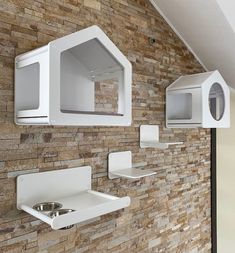 a brick wall with two white microwaves mounted to it's sides and a sink in the middle