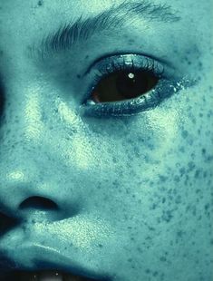 a woman with freckles on her face and blue eyes