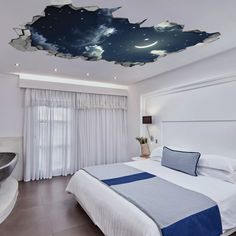 a bed room with a neatly made bed and a night sky mural on the ceiling