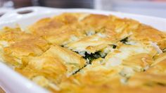 a casserole dish with cheese and spinach in it on a white plate