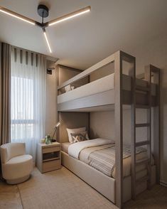 a bedroom with bunk beds in it and a chair next to the bed on the other side