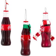 three coca - cola bottles are hanging from chains