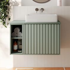 a bathroom with a sink, mirror and green cabinet in the wall next to it