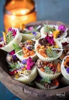 a wooden bowl filled with lots of different types of flowers on top of each other