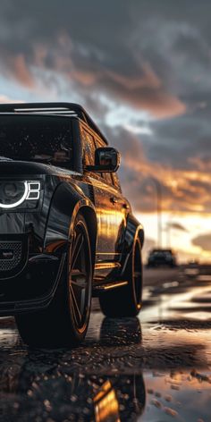 a black suv parked on the side of a wet road at sunset with clouds in the background