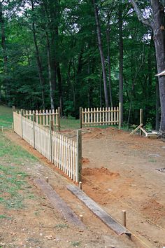 a wooden fence in the middle of a dirt field