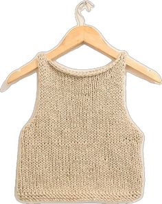 a knitted tank top hanging on a wooden hanger with clothes pins attached to it