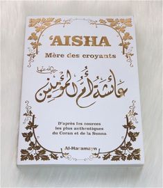 the front cover of a book with arabic writing in gold and white on a white background