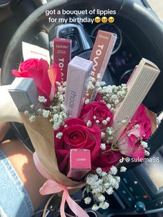 a bouquet of lipstick and flowers in a car with the caption, i got a bouquet of lippies for my birthday