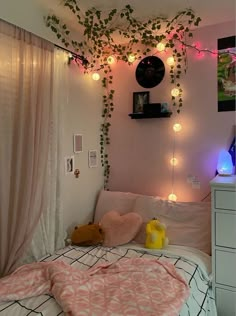 a bedroom decorated in pink and white with hanging lights