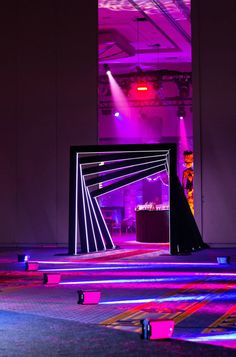 an empty room is lit up with bright lights and purple lighting in the background,