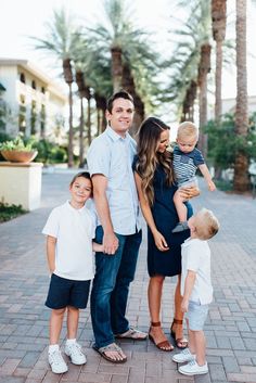 a family posing for a photo in front of palm trees