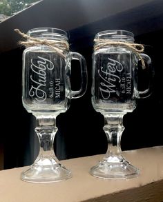 two clear glass mugs with the words coca - cola on them are tied together