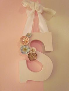 the letter s is decorated with flowers and ribbons