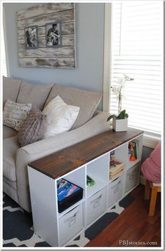 an image of a living room with furniture on the bottom right hand corner and storage drawers below