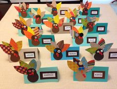 a group of turkeys made out of paper on a table with name tags and place cards