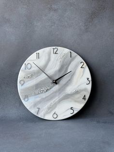 a white clock with black hands on a gray background