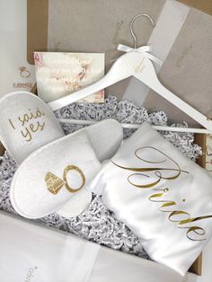 an open gift box with personalized slippers and wedding handkerchiefs in the bottom right corner