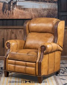 a brown leather recliner chair sitting in front of a wall with a horse on it