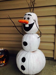 there is a snowman made out of paper plates and carrots on the front porch