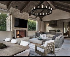 an outdoor living area with couches, chairs and a fireplace