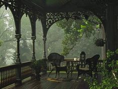 an outdoor gazebo with chairs and tables on the deck in the foggy forest